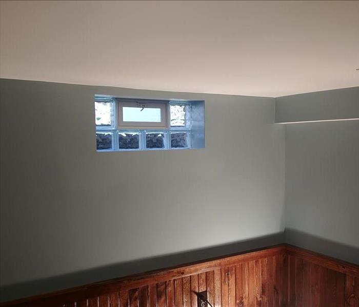 A freshly painted wall with newly installed glass block and wooden trim.