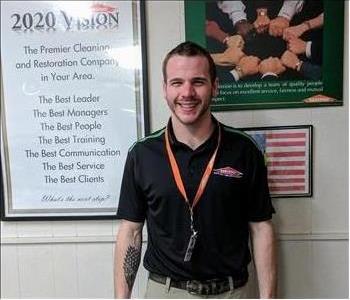 Man standing in front of 2020 Vision Poster and American flag.